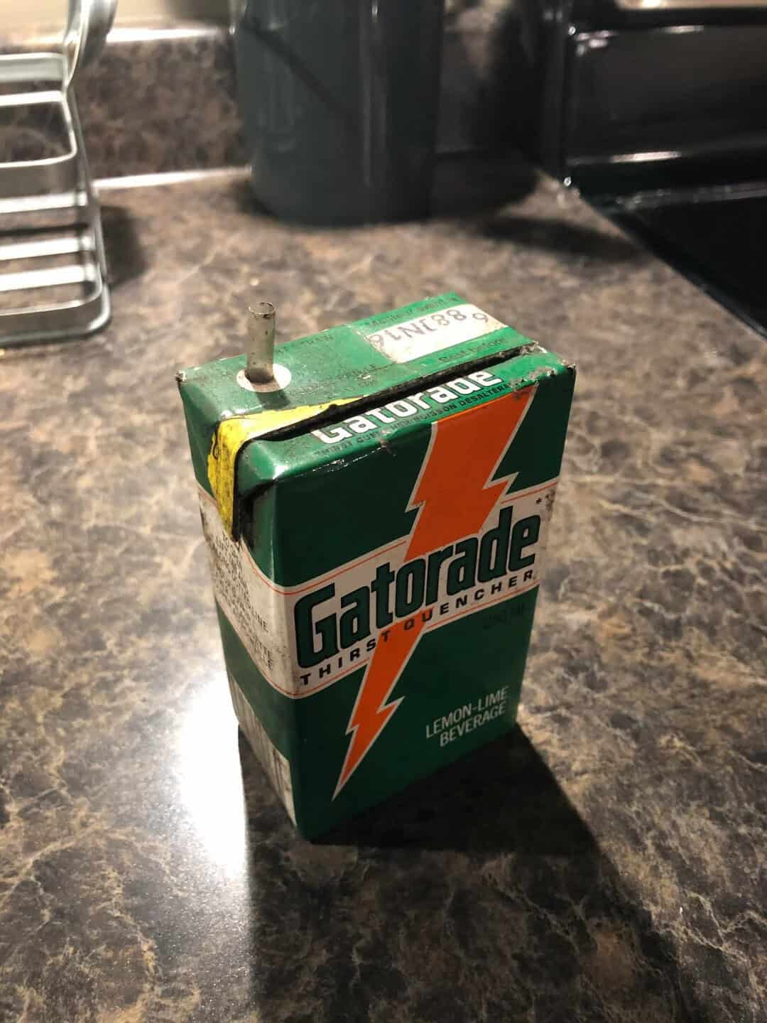 Small Gatorade Lemon-Lime beverage carton with a straw on a kitchen counter.