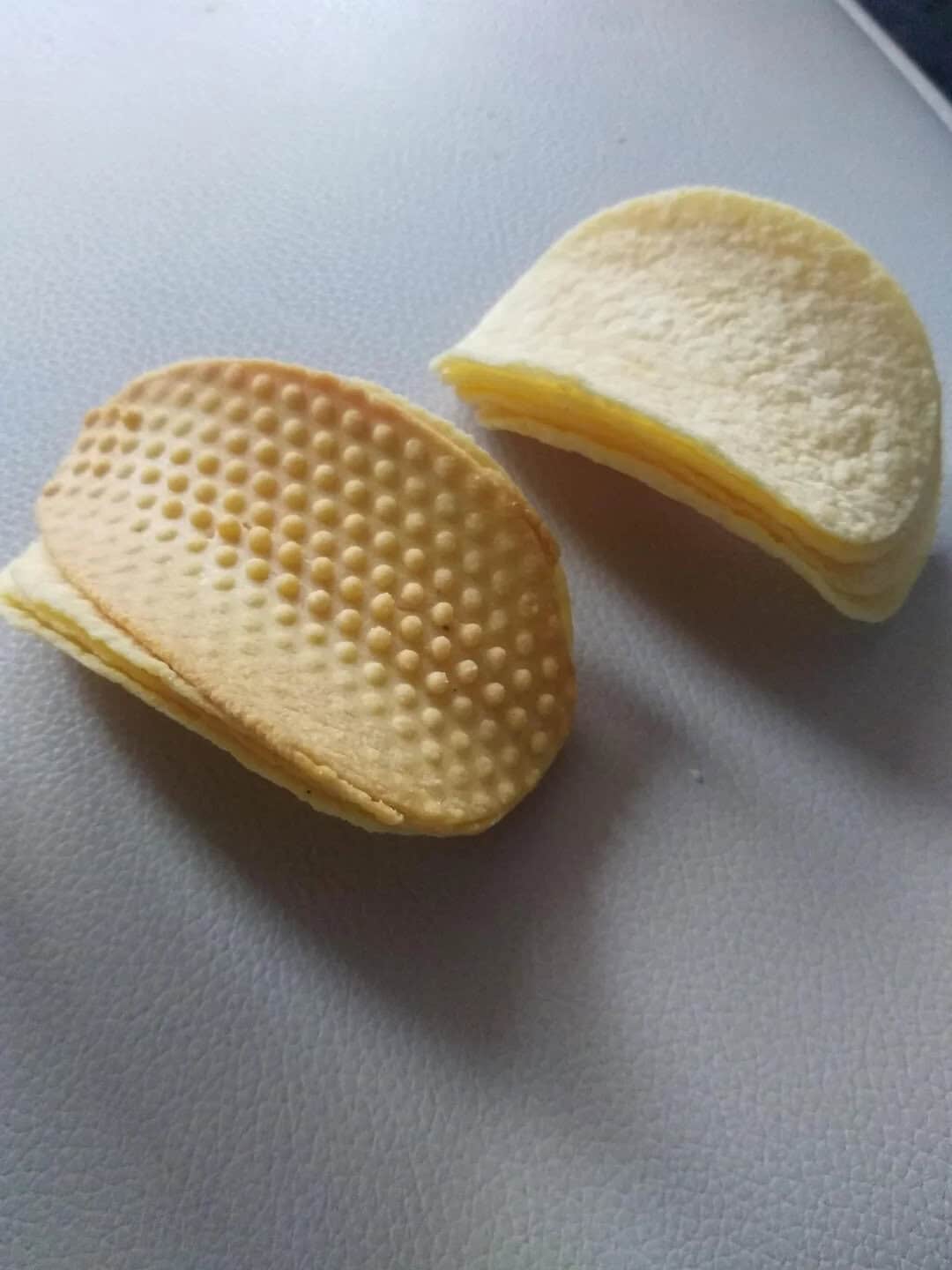 A wafer biscuit with one half showing the textured side and the other half showing the smooth side.