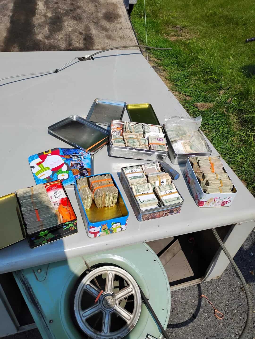 Various stacks of cash and coins on a table outside.