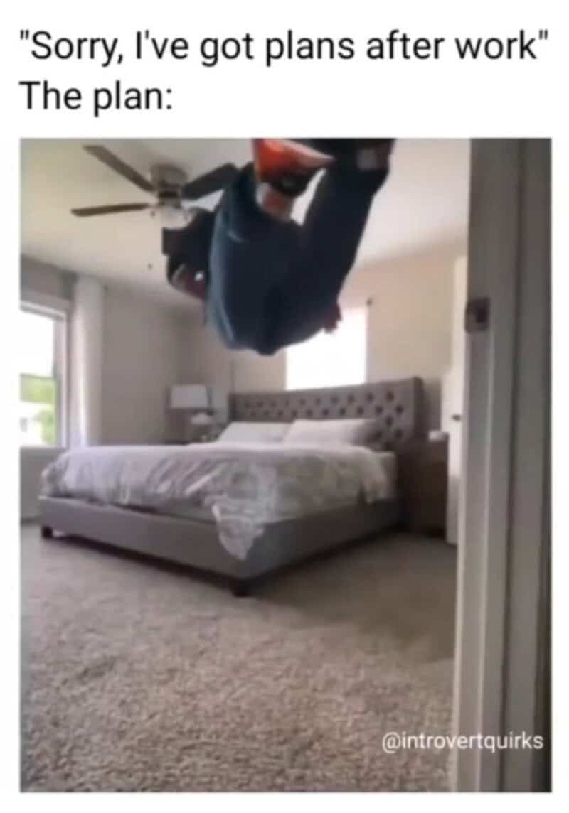 Person hanging upside down in bedroom with bed and window.