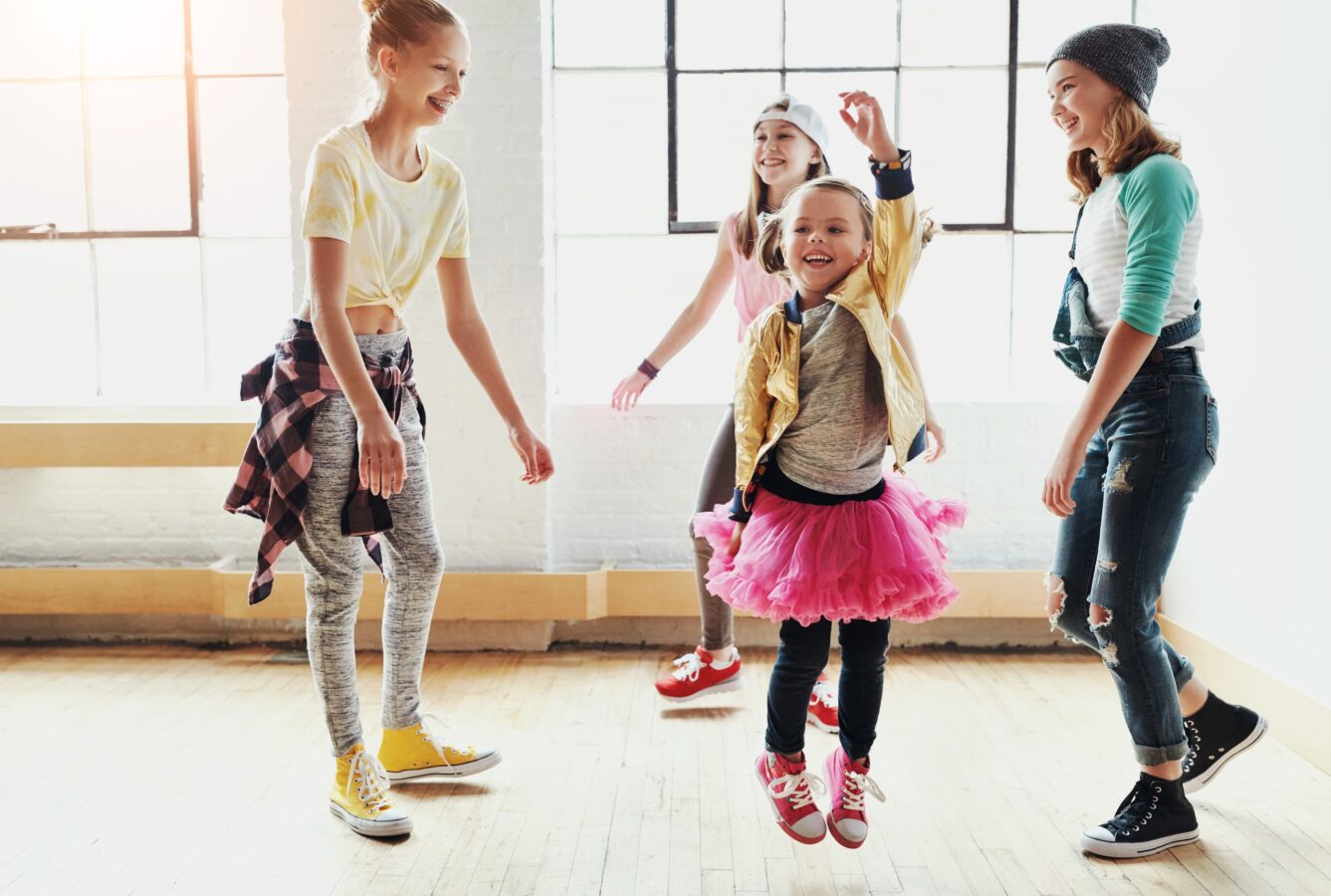 Kids dancing and having fun in a bright room.
