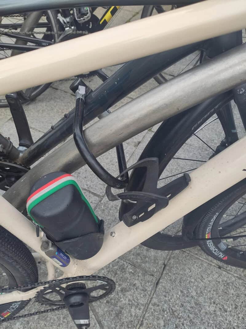 E-bike lock attached to the frame of a bicycle, securing it to a bike rack.