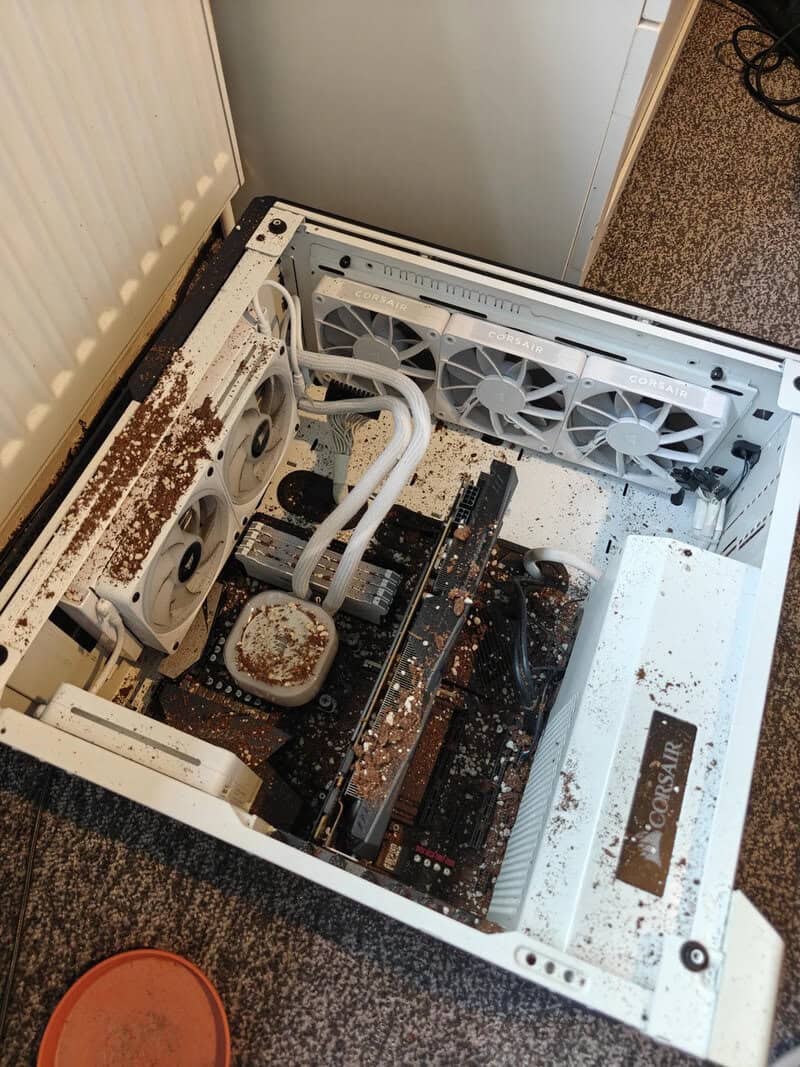 Open computer case with dust and debris inside, cooling fans visible.