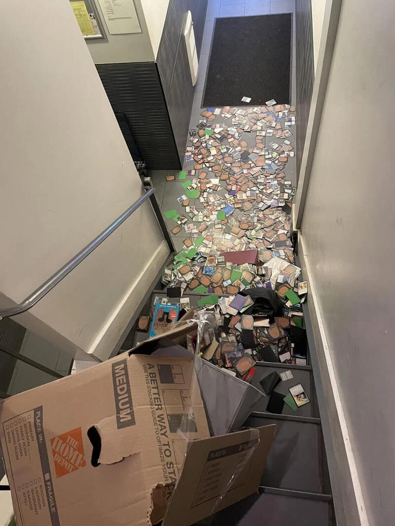 Cluttered hallway with scattered papers, boxes, and debris on the floor.