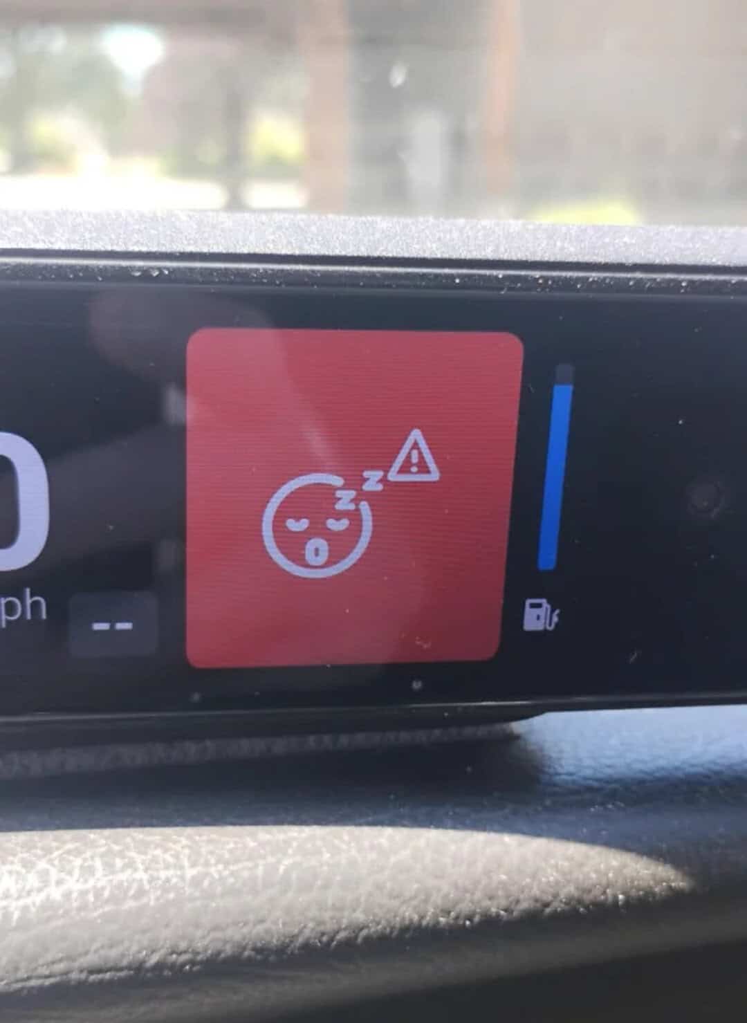 Car dashboard warning with sleepy face, warning triangle, and fuel icon.