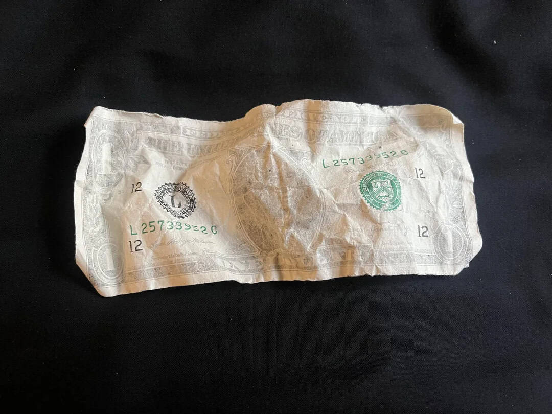 Lira banknote with green and black markings on a black background.