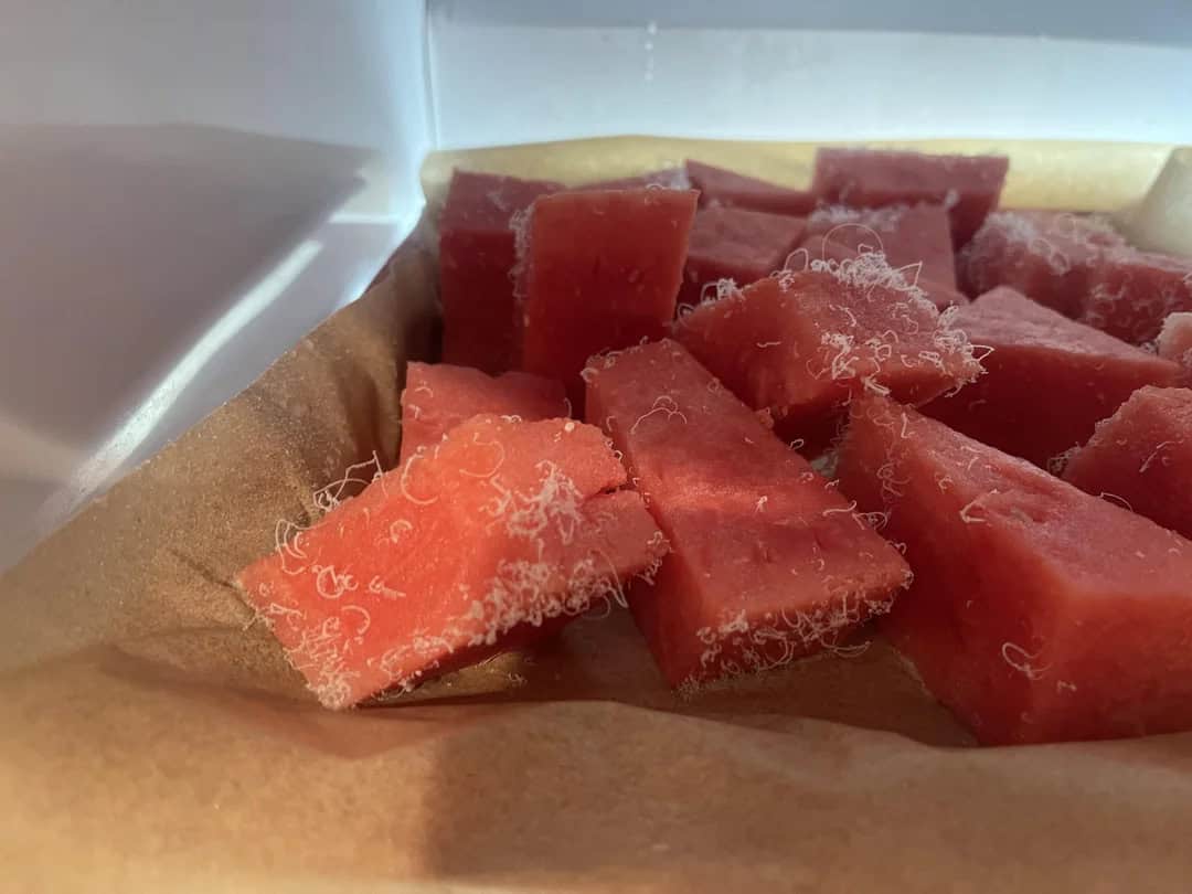 Fresh watermelon and cantaloupe slices on parchment paper.