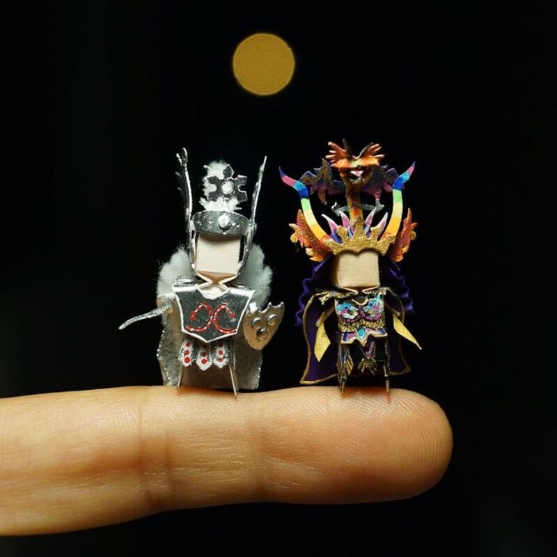Miniature paper art characters with a moon in the background.