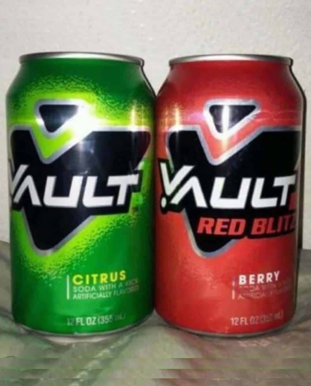 Two 12 fl oz cans of Vault soda, citrus flavor on the left and red blitz berry on the right.