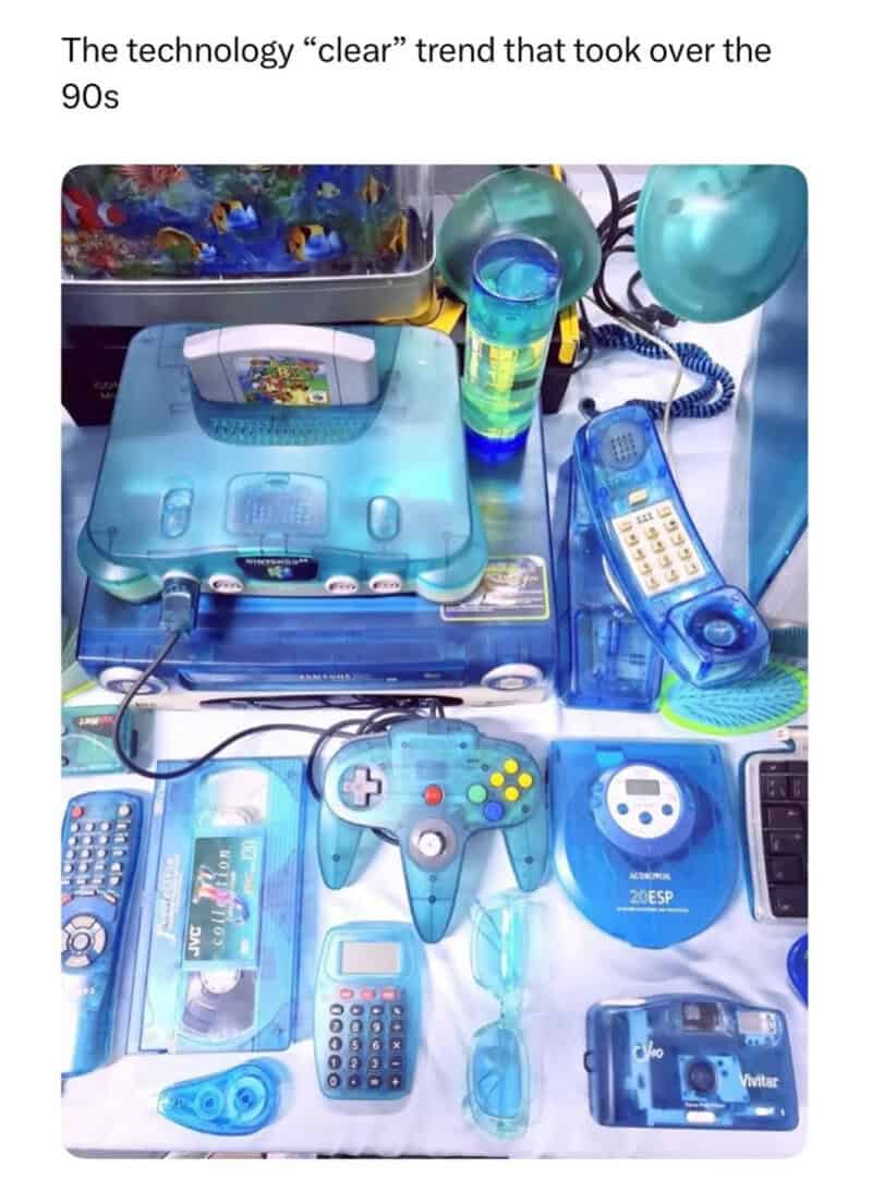 Vintage blue electronics and gadgets from the 90s, including a gaming controller, cordless phone, an.