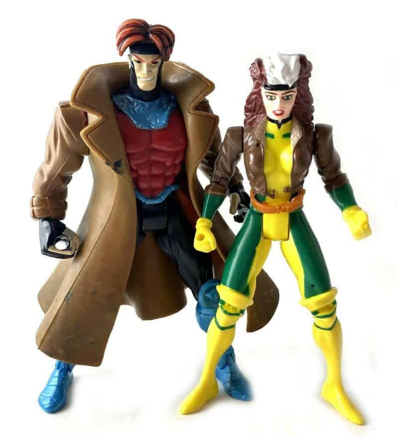 Two vintage 90s toy action figures, one male with a trench coat and the other female in a yellow and.