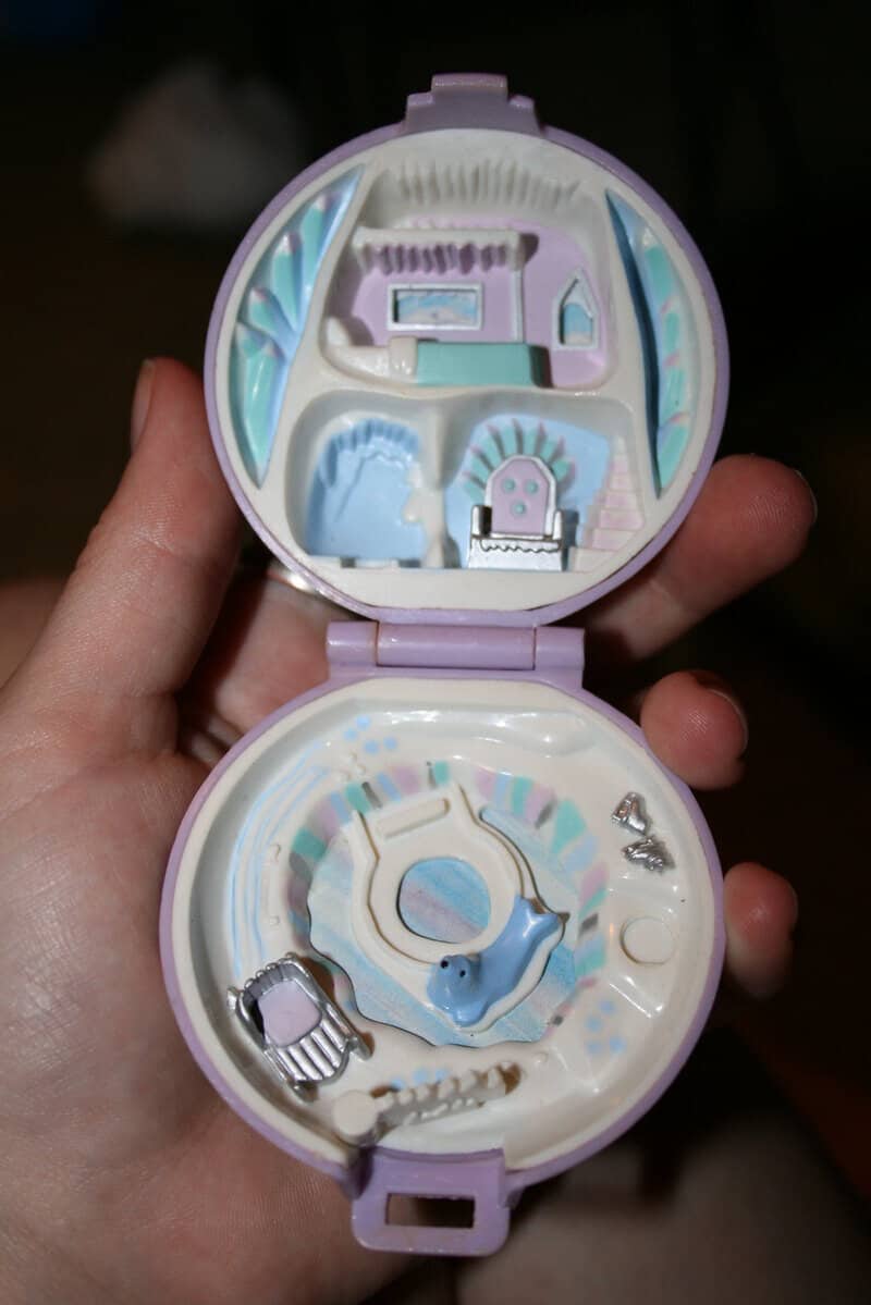 Vintage 90s toy compact with miniature grooming and beauty accessories inside.