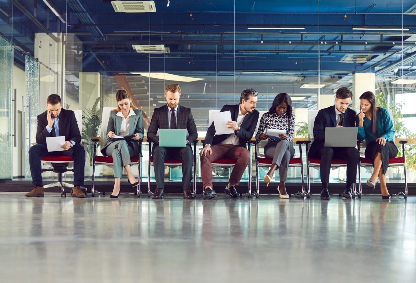 Modern business team waiting in a corporate office lobby.