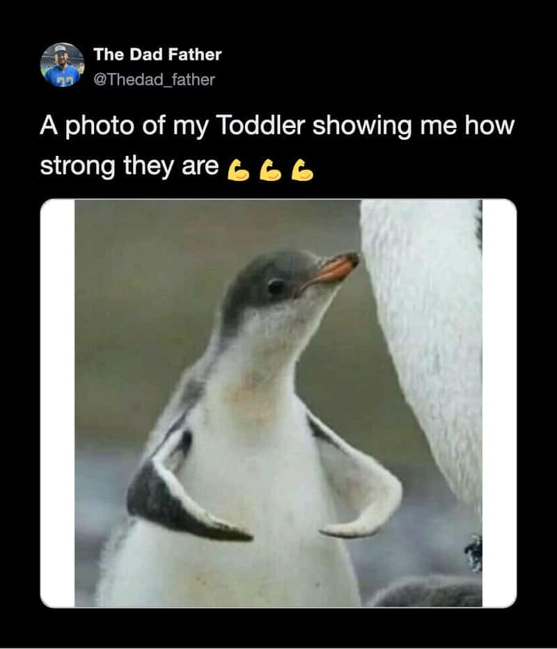 A toddler showing strong arm muscles with a penguin image.