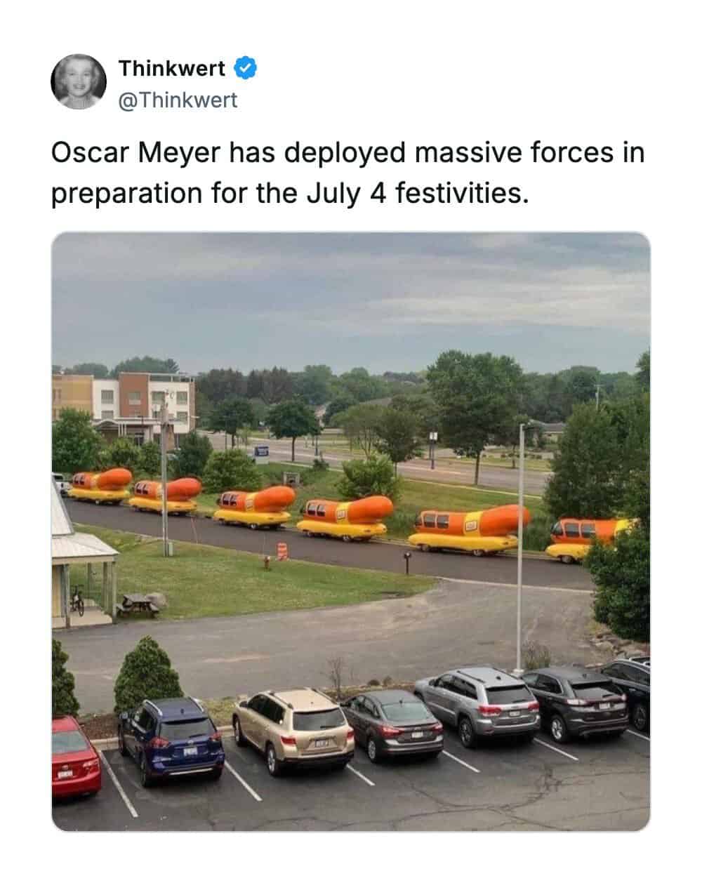 Line of orange and yellow vehicles resembling hot dogs in a parking lot.
