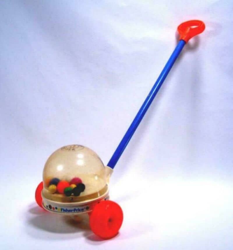 Toy ball with a long handle and red wheels, on a white background.
