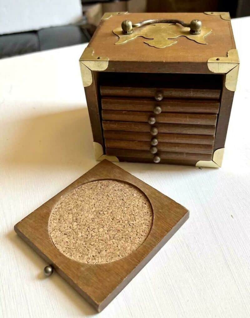 Vintage wooden box with a sliding lid and a cork coaster.