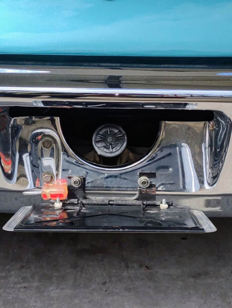 Close-up of a car's front bumper with a missing license plate and a camera.
