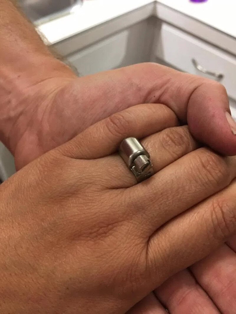 Close-up of two hands, one with a ring, holding each other.