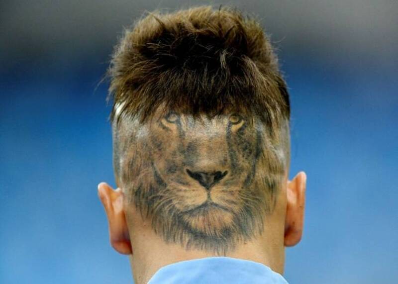 Person with a lion face tattoo on the back of their head.