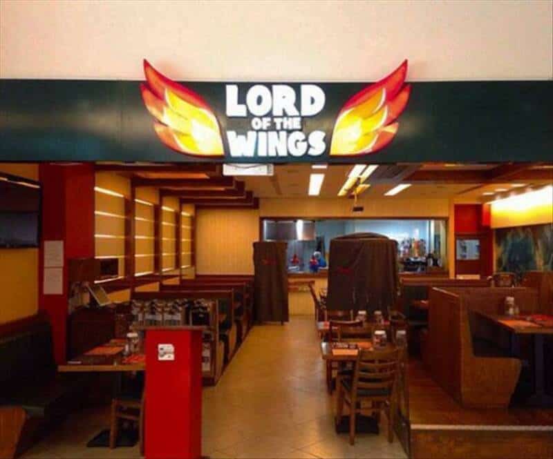 Sign reading 'Lord of the Wings' with wing graphics above restaurant entrance.