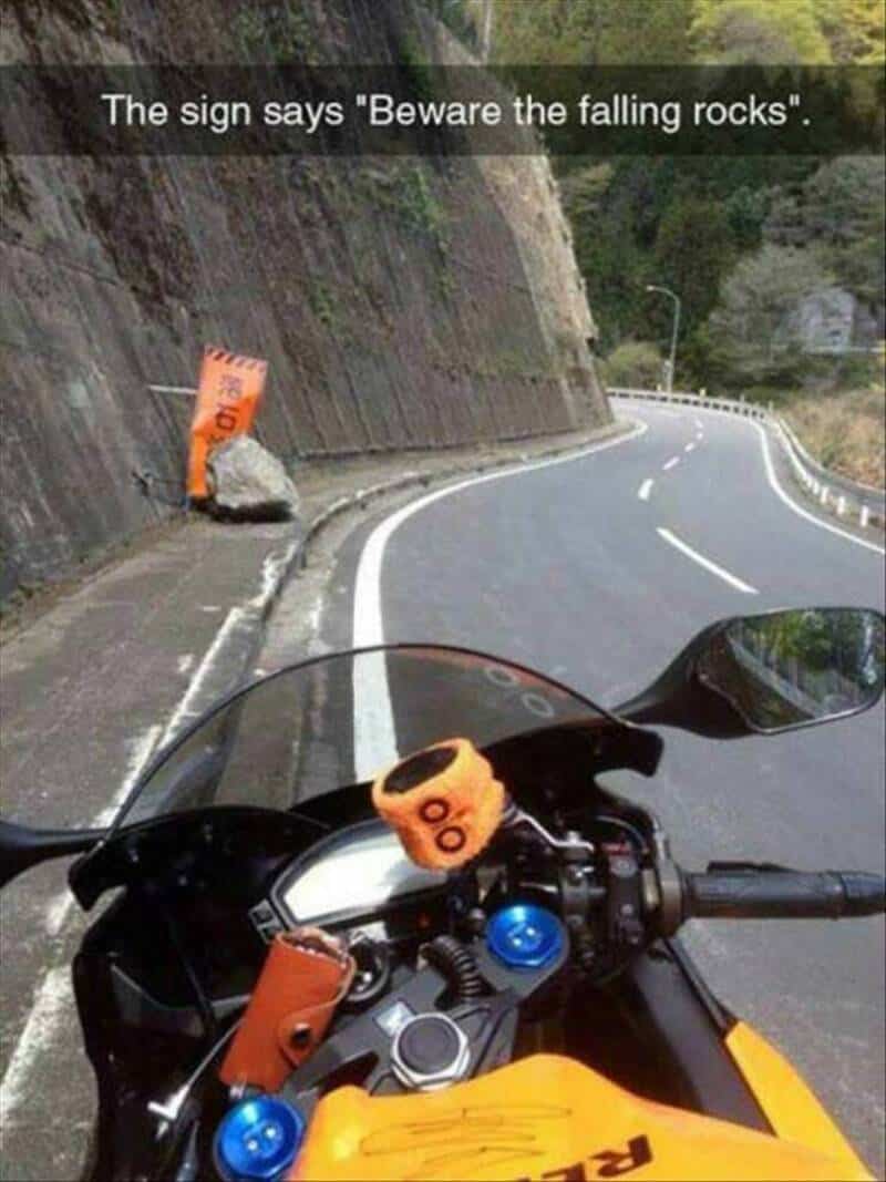 Sign says 'Beware the falling rocks' with a rock and fallen sign on the road.