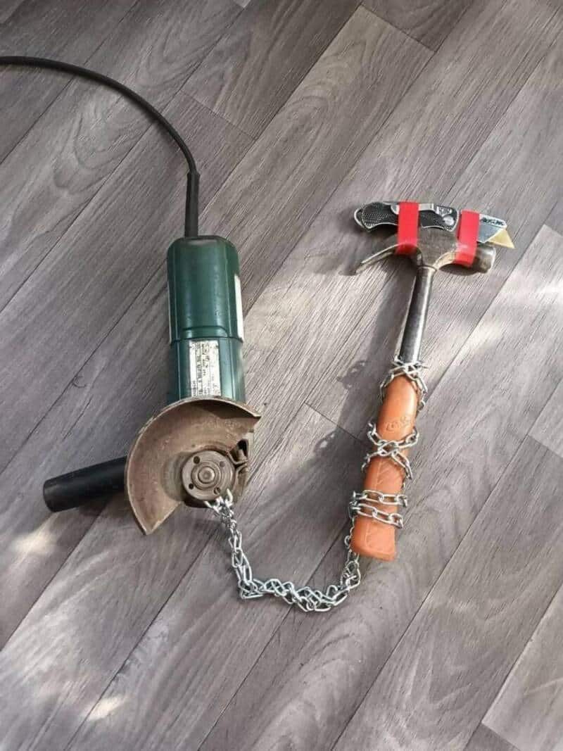 A power tool with a chain, a hammer, and a chain connected to a wooden handle.