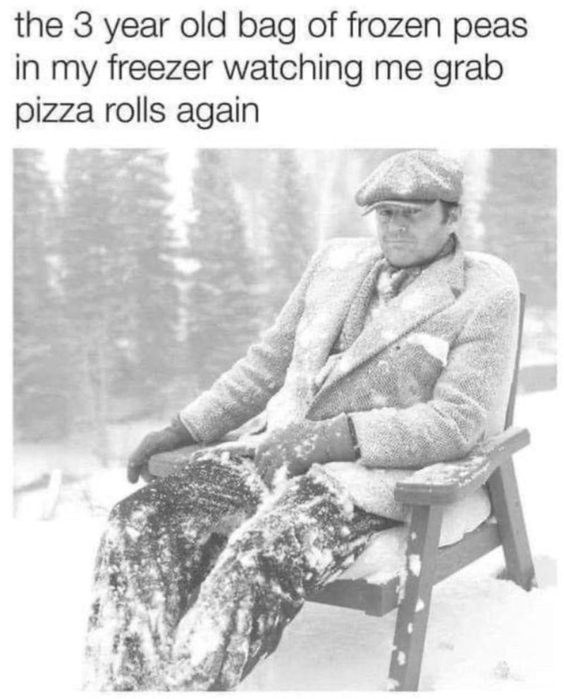 Three-year-old boy with frozen peas on his lap, sitting outside in winter, looking disappointed.