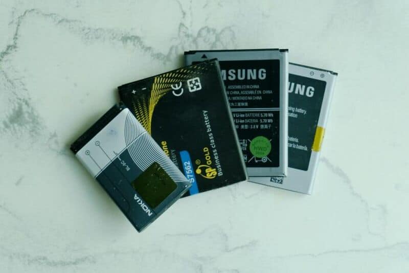 Four Samsung batteries on a white surface with cracks.