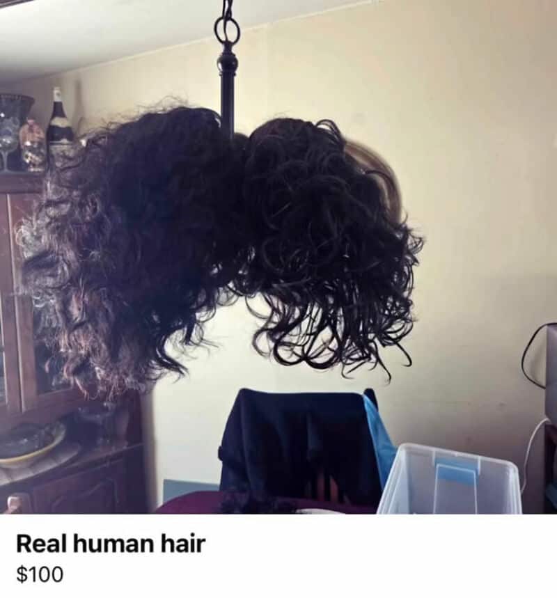 Human hair wig with curly and straight sections hanging on a hook.