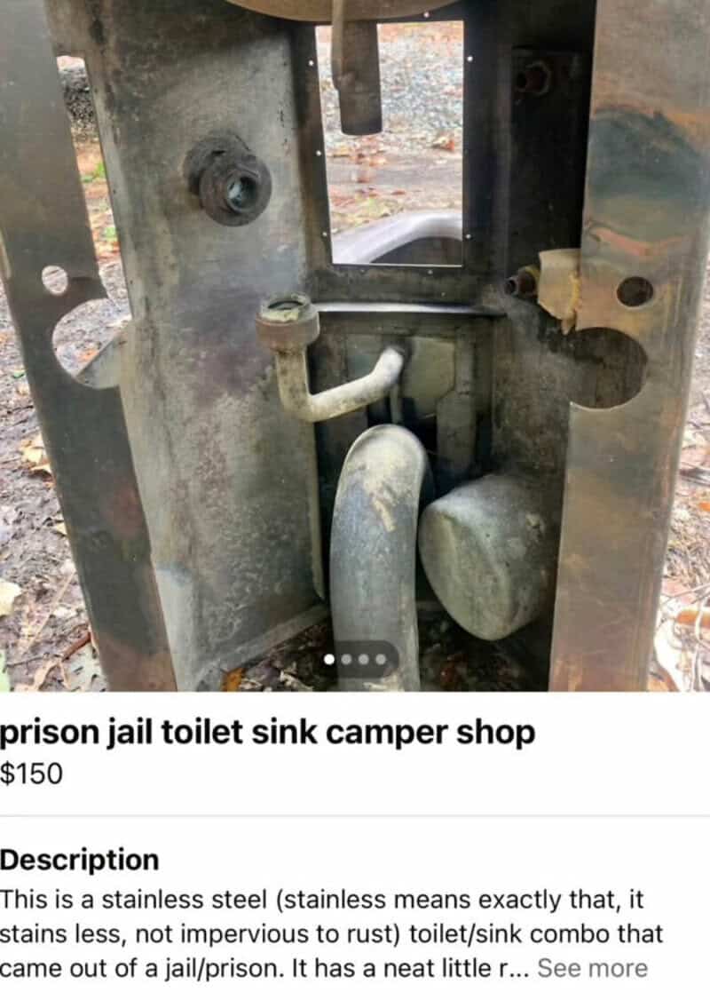 A stainless steel prison jail toilet sink camper shop setup with pipes and rust.