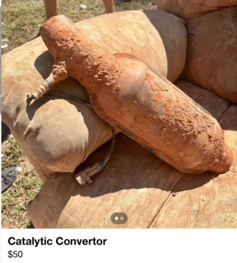Rusty, corroded catalytic converter on outdoor sofa.