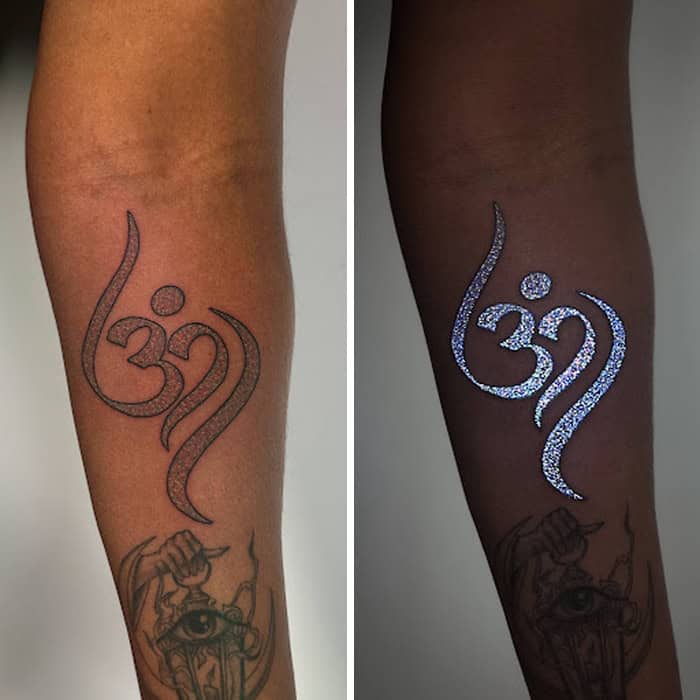 Tattoo of Om symbol with UV-reactive ink on leg, shown under normal and UV light.