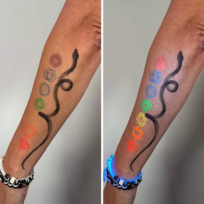Tattoo with colorful geometric shapes and a black snake, shown under UV light.