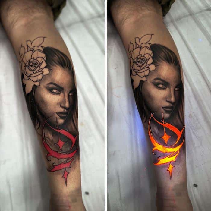 Tattoo of a woman's face with roses and a glowing UV ink design on the arm.