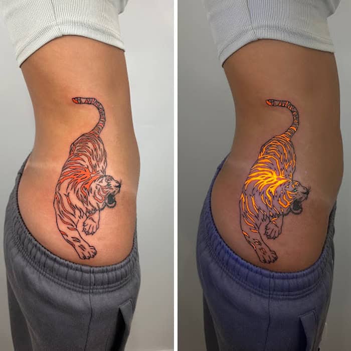 Tattoo of a tiger with UV-reactive ink on person's side.