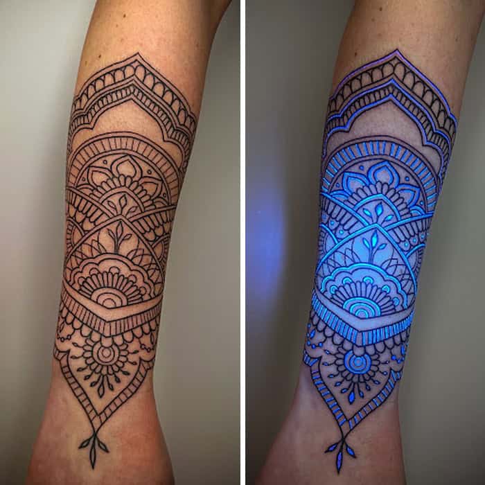 Intricate black tattoo design on forearm, visible under UV light with glowing blue ink.
