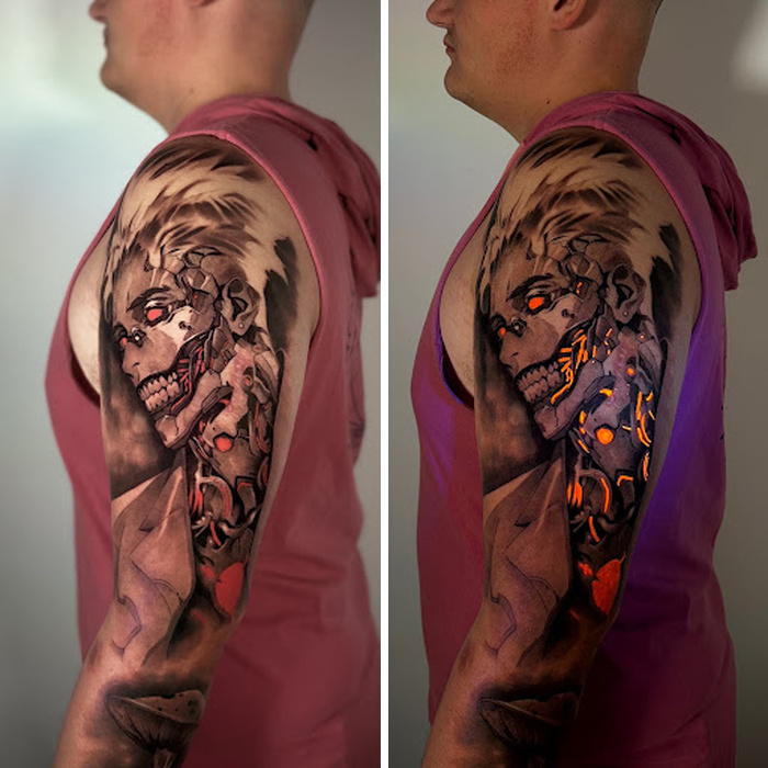 Tattoo of a robotic wolf with glowing orange and purple accents on man's arm.