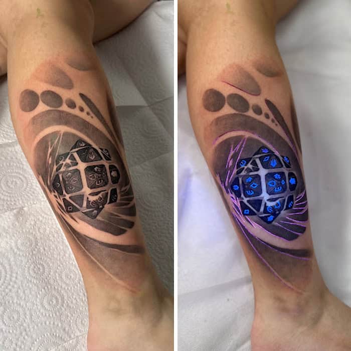Tattoo under UV light showing glowing geometric patterns and symbols.