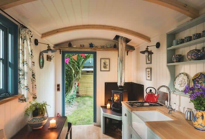 Cozy kitchen with wood accents, open shelves, and a view of the garden through the door.