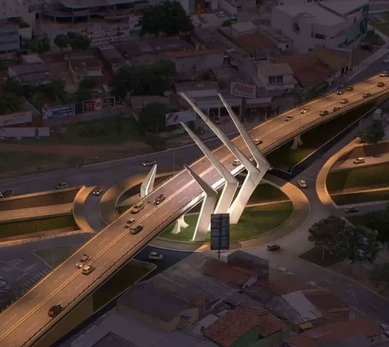 Modern bridge with sharp, angular supports over a busy road intersection.