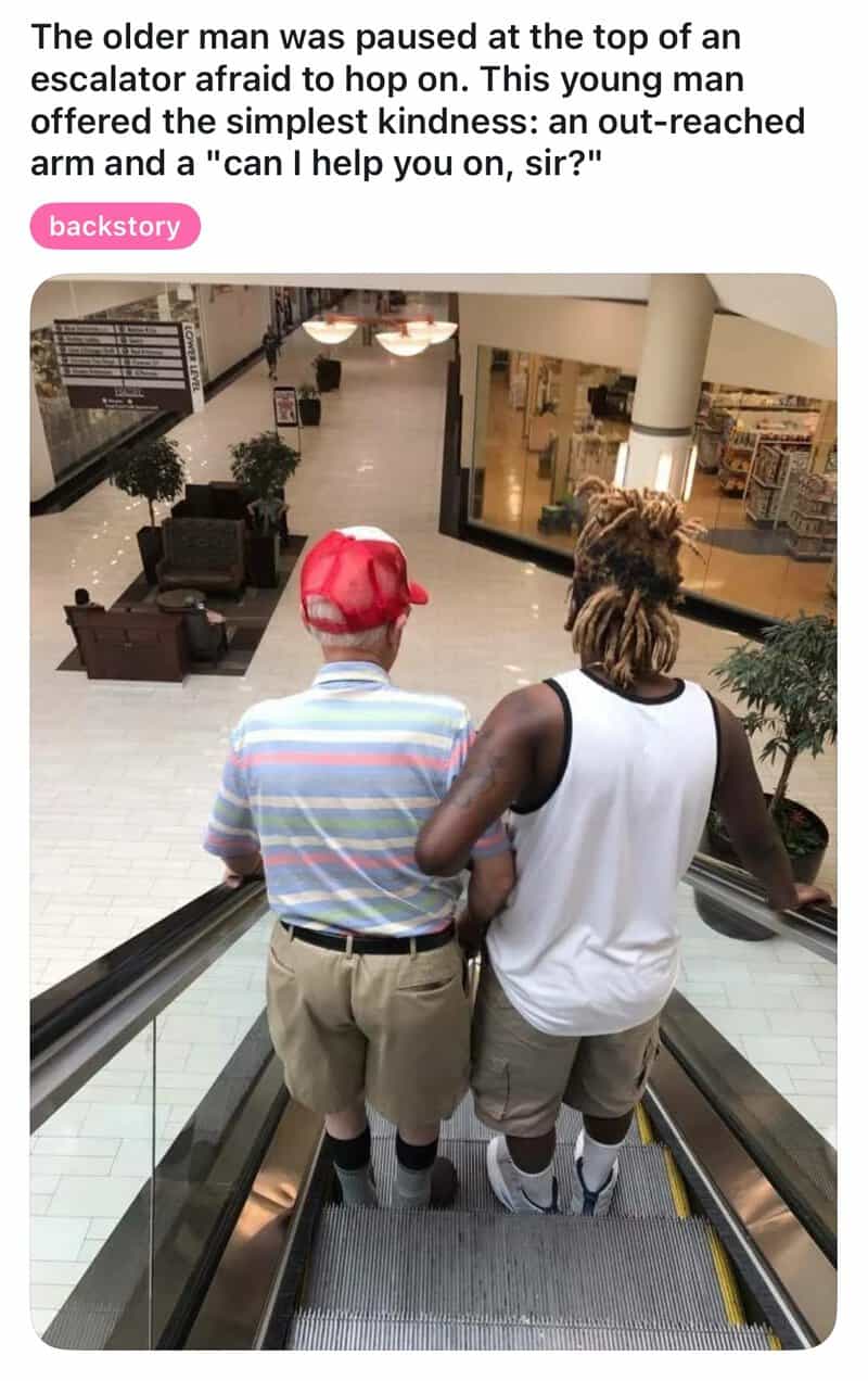 Older man with red cap and young man with dreadlocks on escalator in mall.