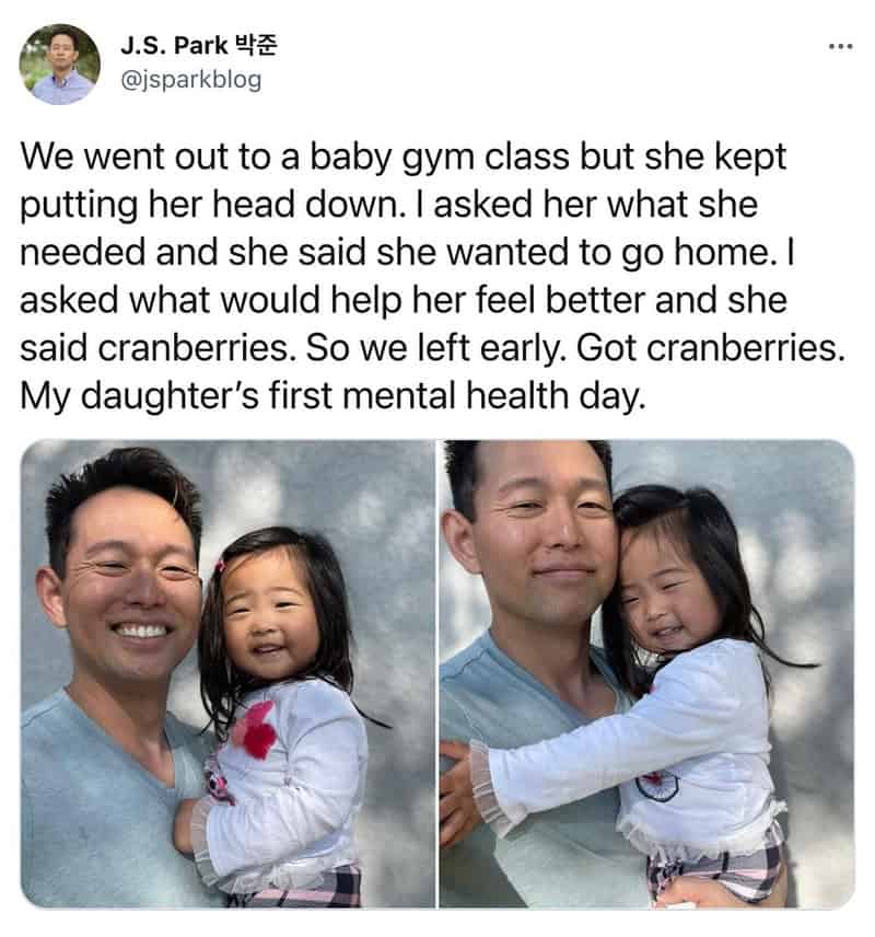 Father and daughter smiling, girl hugging her dad, outdoor setting.