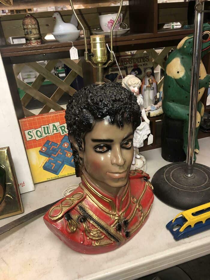 Vintage bust of Michael Jackson with curly hair, dressed in a red military-style jacket, displayed o.