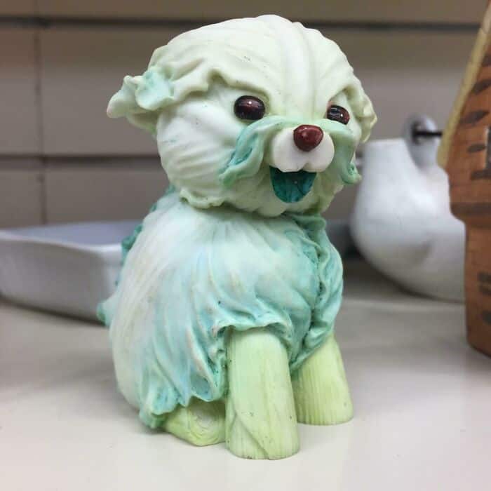 Cute ceramic puppy figurine with a playful expression and pastel colors.