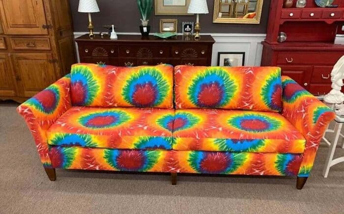 Colorful tie-dye patterned sofa with matching cushions in a living room setting.