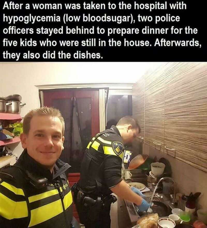 Two police officers preparing dinner in a kitchen, one smiling at the camera.
