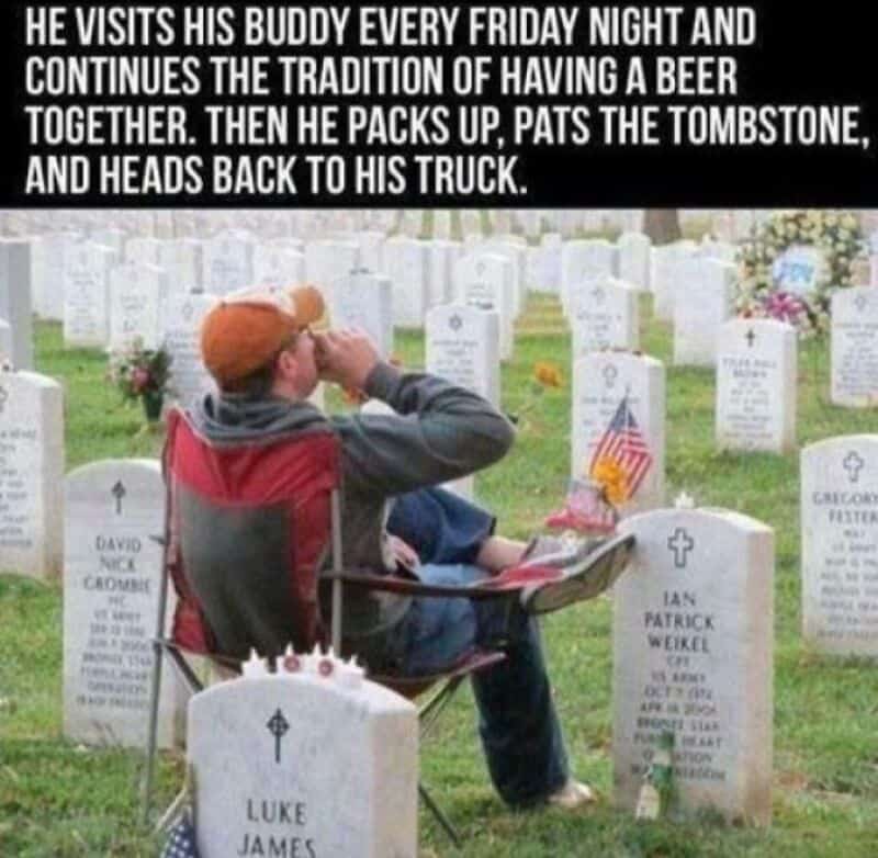 Man visiting a graveyard, sitting on a chair, with a beer, and a flag, surrounded by tombstones.