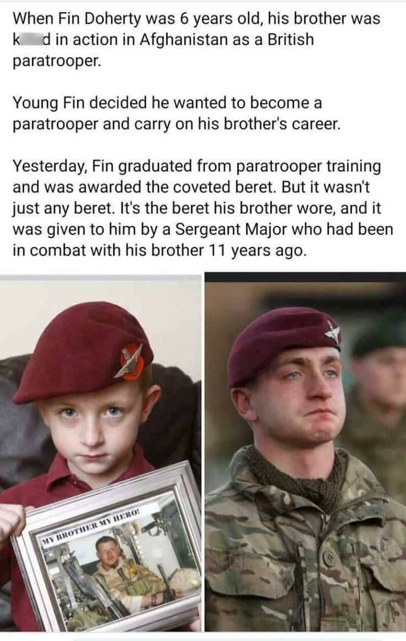 Young boy in a maroon beret holding a framed photo of his brother in military uniform.