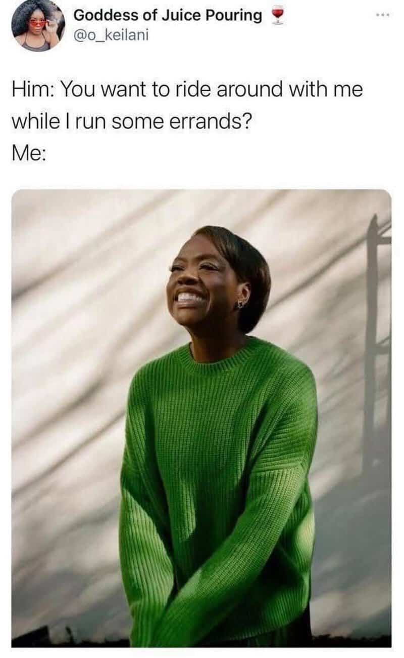 A woman smiling in a green sweater, looking happy and relaxed.